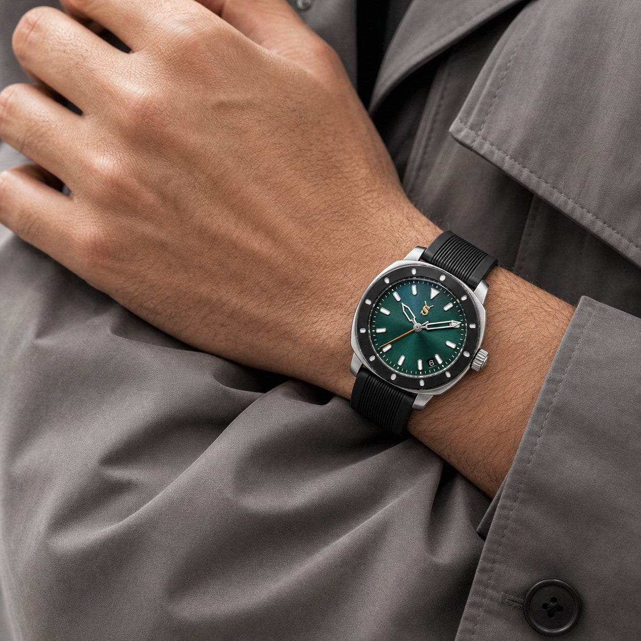 Hand wearing a watch with a green face and black strap, against a gray background.