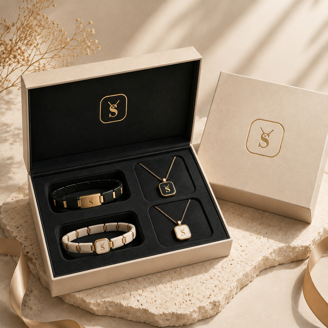 Savwatch premium couple jewelry gift box set. Featuring matching his and hers accessories, including a black and gold link bracelet with a matching pendant necklace, and a complementary white and gold set, presented in a luxury beige box