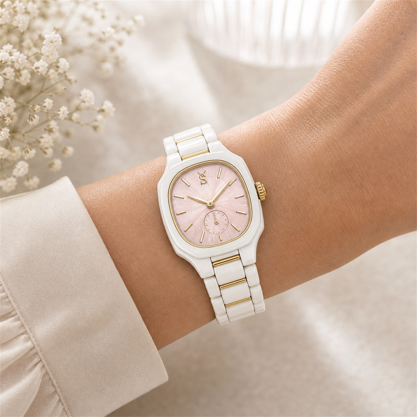 White and gold watch on a wrist with a soft focus background