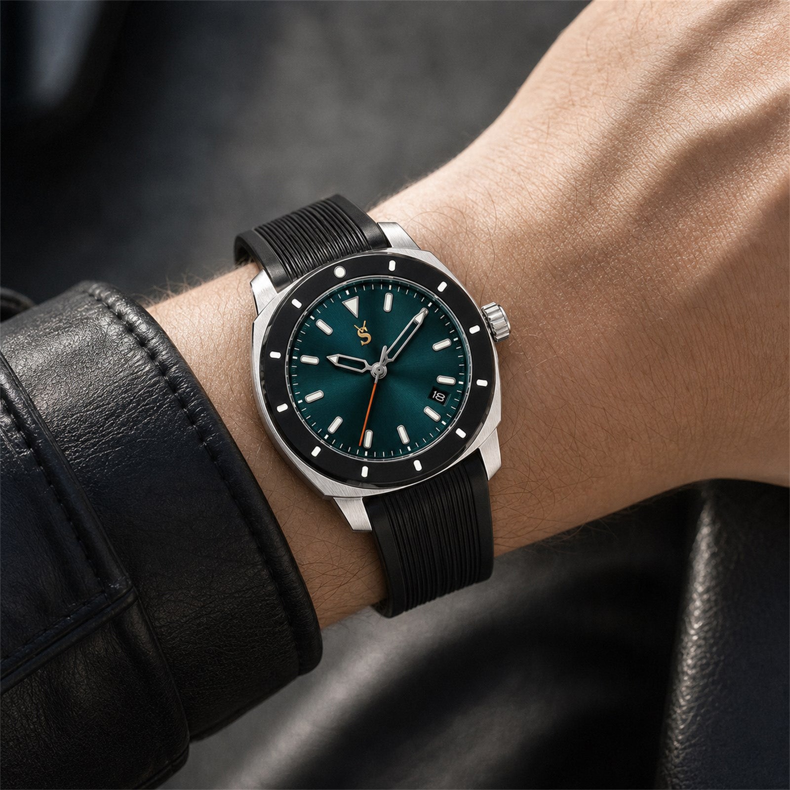 Wrist wearing a black wristwatch with a dark green face on a blurred background